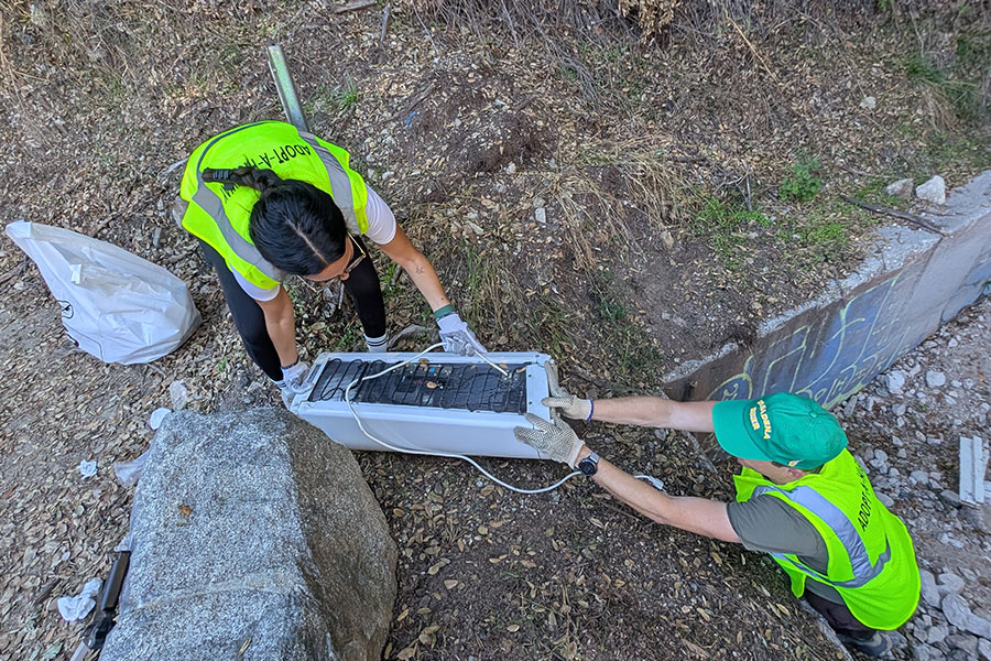 Two volunteers lifting up a heater
